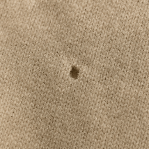 A close-up of a neatly darned hole in a merino wool sweater